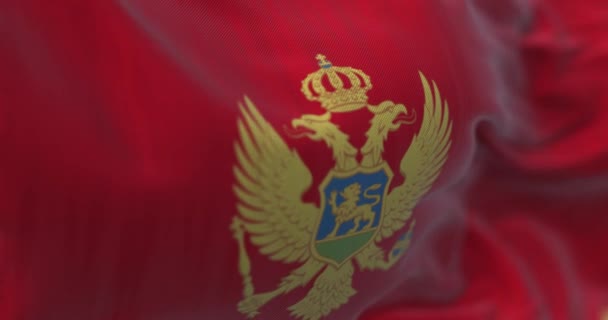 モンテネグロ国旗が風になびく様子を間近で見ることができます モンテネグロは南東ヨーロッパの国です 生地の質感の背景 選択的フォーカス スローモーションで無限ループ 3Dレンダリング — ストック動画