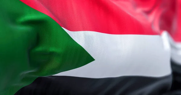 風の中で手を振っスーダン国旗のクローズアップビュー スーダン共和国は北東部アフリカの国です 生地の質感の背景 選択的フォーカス 3Dイラスト — ストック写真