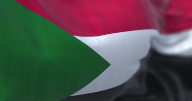 Sudan ulusal bayrağının rüzgarda dalgalanmasının ayrıntıları. Sudan Cumhuriyeti, Afrika kıtasında bulunan bir ülkedir. Kumaş desenli arka plan. Seçici odaklanma. Ağır çekimde sonsuz döngü. 3 Boyutlu Hazırlama