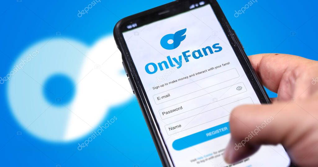 London, UK, August 2021; a hand holds a mobile phone with the OnlyFans registration form on the screen and the logo blurred in the background. OnlyFans is an internet content subscription service