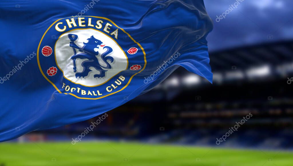 London, UK, May 2022: The flag of Chelsea Football Club waving inside the Stamford Bridge stadium at night. Chelsea F.C. is a professional football club based in Fulham, London