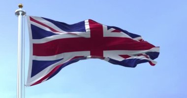 United Kingdom flag waving in the wind on a clear day. Union Jack. Blue field with red, white crosses of patron saints. Rippled fabric. Realistic 3D render. Slow motion loop