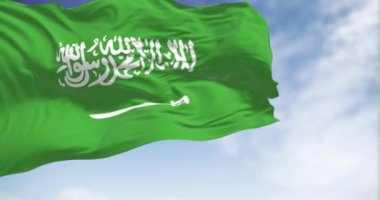 Saudi Arabia national flag waving in the wind on a clear day. Green field with Shahada and sword in Thuluth script. Rippled fabric. Realistic 3D render. Slow motion loop