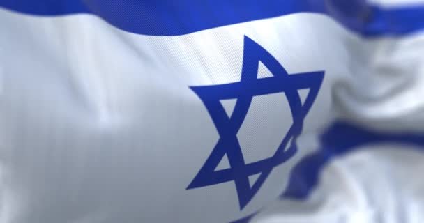 イスラエルの国旗が振ってある 2つの水平方向の青の縞の間の白い背景に青の六角形 リップル生地 背景のテクスチャ 選択的フォーカス 現実的な3Dレンダリング スローモーションループ — ストック動画