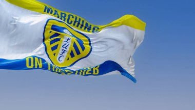 Leeds, UK, Oct. 2022: The Leeds United flag waving in the wind. White shield with blue and yellow stripes, white rose, and LUFC in blue. Rippled fabric. Realistic 3D illustration render.