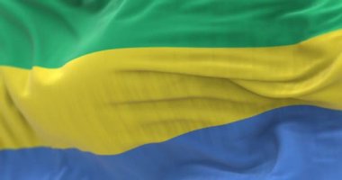The Gabon national flag waving in the wind. The Gabonese Republic is a Central African Country. Close-up. Selective focus. Rippled fabric. Realistic 3D render. Slow motion loop