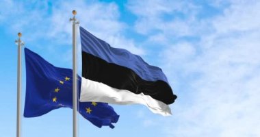 The flags of Estonia and the European Union waving together on a clear day. Estonia became a member of the European Union on May 1, 2004. Rippled fabric. Realistic 3D render. Slow motion loop