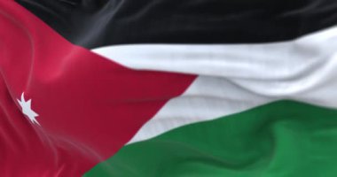 Perspective view of the Jordan national flag waving. Horizontal black, white and green striped flag with red triangle. Fluttering textile. Selective focus. 3d render animation. Slow motion loop