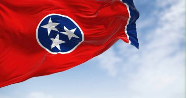 Tennessee state flag waving on a clear day. Three white stars inside a blue circle on a red background with a white stripe and a blue band on the right. Fluttering fabric. 3d illustration.