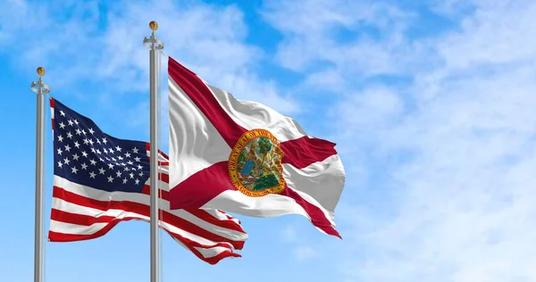 Florida state flag waving with the national flag of the United States of America on a clear day. Rippled textile. 3d illustration.