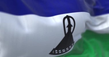 Detail of the Lesotho national flag waving. Horizontal blue, white, and green with a black mokorotlo in the center. Fluttering textile. Selective focus. 3d render animation. Slow motion loop. Close-up