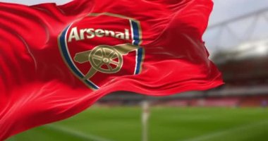 London, UK, DEC 2022: Arsenal Football Club flag waving with the Emirates Stadium blurred in the background. Rippled Fabric. Selective focus. Realistic 3d render animation. Looping slow motion