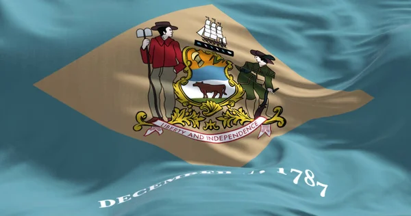 Close-up view of the Delaware state flag fluttering. Colonial blue background with a buff-colored diamond and state coat of arms, and December 7, 1787 below it. Textured background. 3d illustration