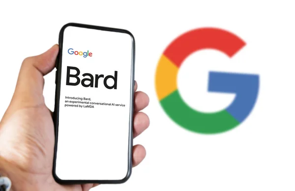 stock image San Francisco US, Feb 2023: A hand holding a phone with the Google Bard website on the screen. White background with blurred Big G logo. Bard is Google artificial intelligence chatbot