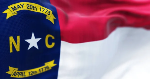 North Carolina state flag waving. North Carolina is a state in the Southeastern region of the United States. Rippled fabric. 3d illustration render. Selective focus. Close-up.