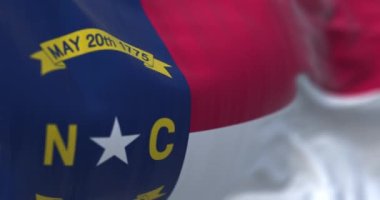 Kuzey Carolina bayrağı dalgalanıyor. Kuzey Carolina, ABD 'nin güneydoğu bölgesinde bir eyalettir. 3D canlandırma canlandırması. Seçici odaklanma. Yavaş çekim döngüsü. Yakın plan. Desenli kumaş arkaplanı