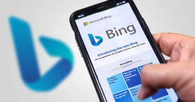 Redmond, ABD, Şubat 2023: Ekranda Microsoft Bing 'in web sitesini tutan bir el. Bulanık Bing logosuna sahip beyaz arka plan. Bing, AI Chatbot ile entegre edilmiş bir arama motoru.