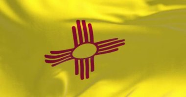 New Mexico bayrağının dalgalandığı yakın çekim. Amerikan bayrağı. Ortasında kırmızı Zia sembolü olan sarı alan. Kusursuz 3 boyutlu animasyon. Seçici odaklanma. Yavaş çekim döngüsü. Yakın plan..