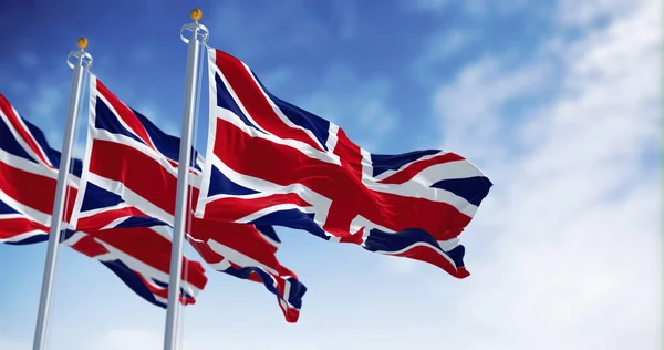 Three national flags of the United Kingdom waving in the wind on a clear day. 3D illustration render. Rippled textile.