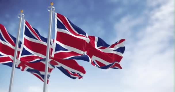 晴れた日には英国の3つの国旗が風になびく シームレスな3Dレンダリングアニメーション スローモーションループ 破れた織物 — ストック動画