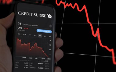 New York, US, March 2023: hand holding a phone with the performance of Credit Suisse on stock market. In March 2023, Credit Suisse experienced a sharp drop in its stock price. Illustrative editorial clipart