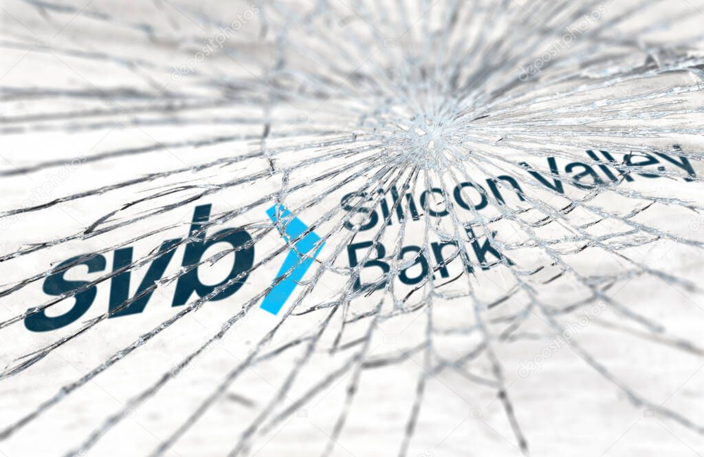 Santa Clara, USA, March 2023: Broken glass with the Silicon Valley Bank logo blurred in the background. Bank run and bankruptcy. Finance and economy. Illustrative editorial