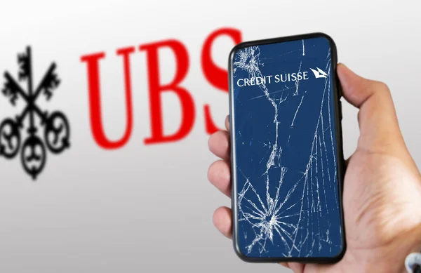 2023年3月ニューヨーク クレジットスイスのロゴが入った携帯電話を割れた画面で手に取る Ubsのロゴが白地でぼやけている Ubsはクレジットスイスを3Bhで購入しました 挿絵画集 — ストック写真