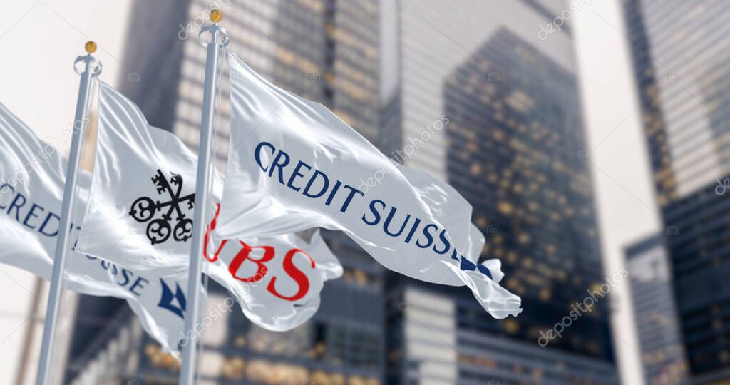 Zurich, CH, March 2023: Flags of Credit Suisse and UBS fluttering in the wind in a financial district. In March 2023, UBS bought Credit Suisse. Illustrative editorial 3d illustration render