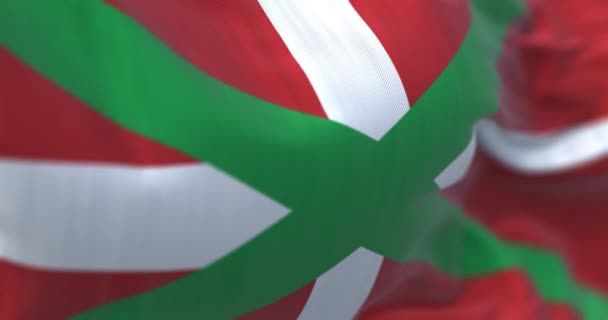 バスク地方の国旗が振ってある スペイン北部の自治体 赤い畑の緑の塩水の上に白い十字架 3Dレンダリングアニメーション スローモーション シームレスなループだ 選択的フォーカス — ストック動画