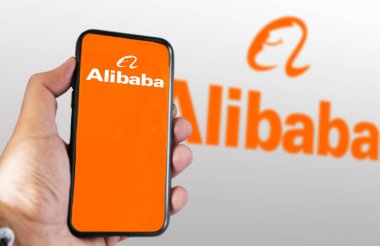 Pekin, CN, Mart 2023: ekranda Alibaba mobil uygulaması ile el ele tutuşmak. 2023 Mart 'ında Alibaba Gourp işini 6 ayrı birime ayırmaya karar verdi. İllüstrasyon Editörü