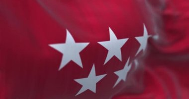 Madrid Topluluğunun rüzgarda dalgalanan bayrağı. Kırmızı, yedi gümüş uçlu, beş köşeli yıldız. 3D canlandırma canlandırması. Ağır çekim. Kusursuz döngü. Seçici odaklanma. Yakın plan.