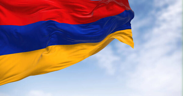 The national flag of Armenia waving in the wind on a clear day. Three horizontal bands in red, blue and apricot. 3d illustration render. Rippled textile
