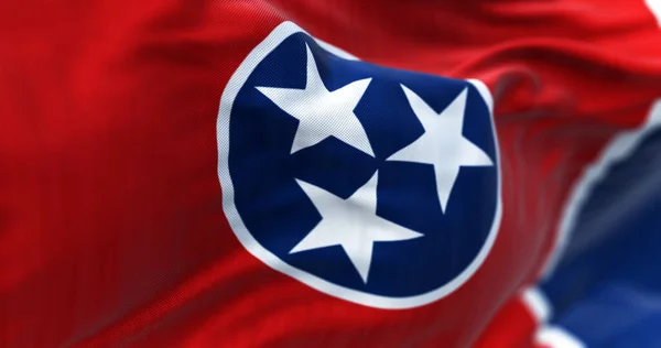 stock image Close-up of the Tennessee state flag waving. Red field with a blue circle holding 3 white stars outlined in white. Blue strip on the fly. 3d illustration render. Textured background. Selective focus