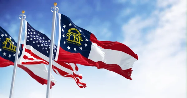 The flags of Georgia and United States waving in the wind on a clear day. Georgia is a state in the southeastern US. US federate state. 3d illustration render. Selective focus. Fluttering textile