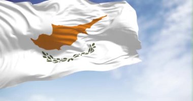 Kıbrıs ulusal bayrağı açık bir günde dalgalanıyor. Beyaz, bakır-turuncu bir ada silueti ve altında iki yeşil zeytin dalı. Kusursuz 3 boyutlu animasyon. Yavaş çekim döngüsü. Dalgalanan tekstil
