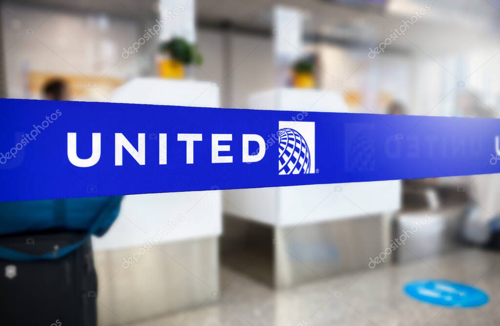 Chicago, US, Jan 2023: Blue retractable belt barrier with white United Airlines logo. United is a major American airline. Travel and airport security. Illustrative editorial