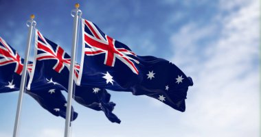 Açık bir günde rüzgarda dalgalanan üç Avustralya bayrağı. Union Jack ile mavi bayrak, Güney Haçı 'nı simgeleyen 5 köşeli beyaz yıldız. Dalgalı kumaş. 3B illüstrasyon oluşturucu