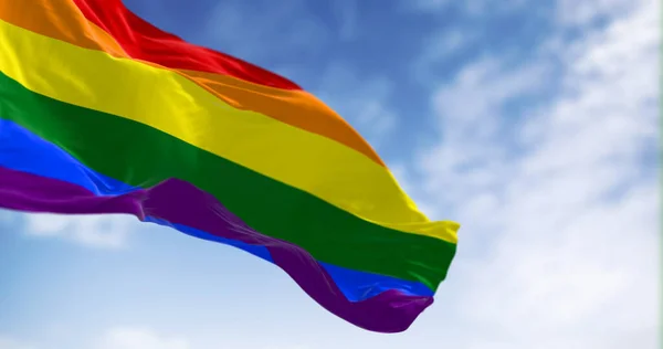 Rainbow flag waving on a clear day. Multicolored flag with stripes in the colors of the rainbow, often used as a symbol of LGBT pride. 3d illustration render. Selective focus. Fluttering fabric