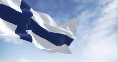 Açık bir günde Finlandiya bayrağı dalgalanır. Beyaz arka planda mavi İskandinav haçı. İskandinav ülkesi. Kusursuz 3 boyutlu animasyon. Yavaş çekim döngüsü. Seçici odaklanma. Kanat çırpan kumaş. Yakın plan.
