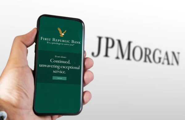 2023年3月 美国旧金山 手持屏幕上印有第一共和国银行标志的手机 背后的Jp摩根标志模糊不清 Frb被摩根大通收购 说明性编辑 — 图库照片
