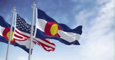 Colorado eyaleti bayrağı açık bir günde Amerika Birleşik Devletleri bayrağıyla dalgalanıyor. Kusursuz 3 boyutlu animasyon. Yavaş çekim döngüsü. Seçici odaklanma. Kanat çırpan kumaş. Yakın plan.