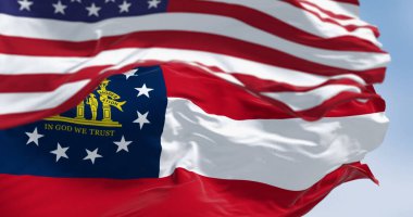 Gürcistan ve ABD bayrakları açık bir günde rüzgarda sallanıyor. Georgia, ABD 'nin güneydoğusunda bir eyalettir. Birleşik Devletler Federal Eyaleti. 3D illüstrasyon canlandırıcı. Seçici odaklanma. Dalgalanan tekstil