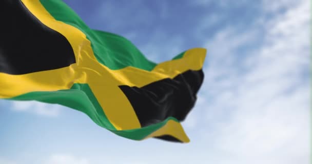 牙买加国旗在晴朗的日子飘扬 黄金盐分为四个部分 两个绿色和两个黑色 无缝3D渲染动画 慢动作回圈有选择的重点 飘扬的面料 — 图库视频影像