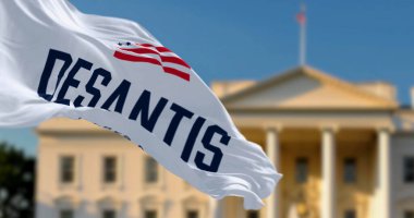 Washington D.C., ABD, Nisan 2023: Ron DeSantis 2024 başkanlık seçim kampanyası logosunun bulanık bir Beyaz Saray önünde sallandığı bayrak. Resimli 3d illüstrasyon oluşturucu
