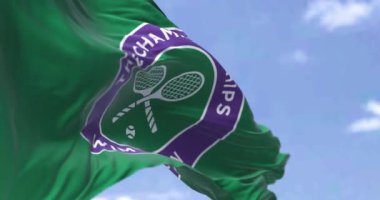 Londra, İngiltere, Mayıs 2023: Wimbledon Şampiyonası logosu rüzgarda sallanan bayrak. Büyük tenis turnuvası. 3D canlandırma canlandırması. Yavaş çekim döngüsü. Seçici odaklanma. Kanat çırpan kumaş. Yakın plan.