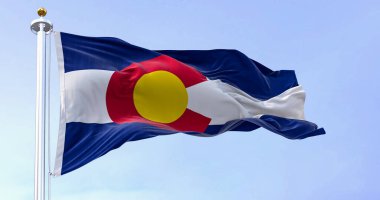 Colorado eyaleti bayrağı açık bir günde rüzgarda dalgalanıyor. Üç mavi, beyaz ve mavi şerit. Üstünde altın diski olan kırmızı C. 3 boyutlu illüstrasyon. Kanat çırpan kumaş. Seçici odak