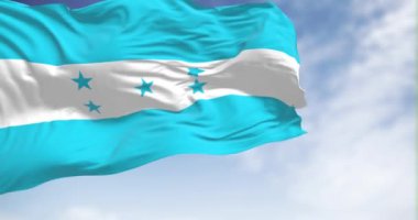 Honduras bayrağı açık bir gökyüzünde dalgalanıyor. Ulusal gurur, kimlik ve bağımsızlığın sembolü. Kusursuz 3 boyutlu animasyon. Yavaş çekim döngüsü. Kanat çırpan kumaş. Yakın plan.