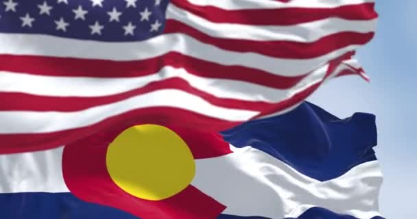 コロラド州旗は晴れた日にアメリカ合衆国の国旗を振っている シームレスな3Dレンダリングアニメーション スローモーションループ 選択的フォーカス フラッタリング生地 接近中だ — ストック動画