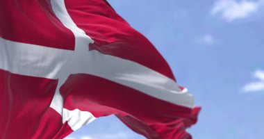 Danimarka ulusal bayrağı açık bir günde rüzgarda sallanıyor. Danimarka Krallığı Kuzey Avrupa 'da bir İskandinav ülkesidir. Kanat çırpan kumaş. Kusursuz 3 boyutlu animasyon. Yavaş çekim döngüsü. Seçici odaklanma. Kanat çırpan kumaş. 4k