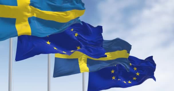 在一个晴朗的日子里 瑞典和欧盟的旗帜在一起挥动着 瑞典于1995年成为欧盟成员国 无缝3D渲染动画 慢动作回圈有选择的重点 飘扬的面料 — 图库视频影像